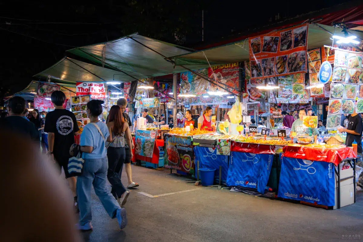 Mehrere Streetfoodstände auf einem Nachtmarkt in Bangkok
