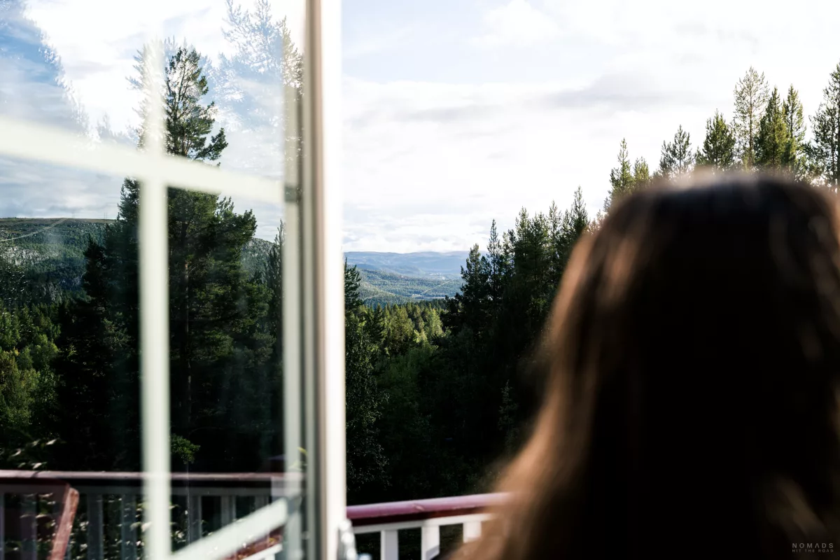 Blick auf einem Fenster an der eine Person steht auf das Tal bei Alta