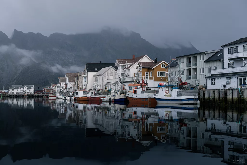 Boote spiegeln sich im Hafenbecken in Henningsvaer