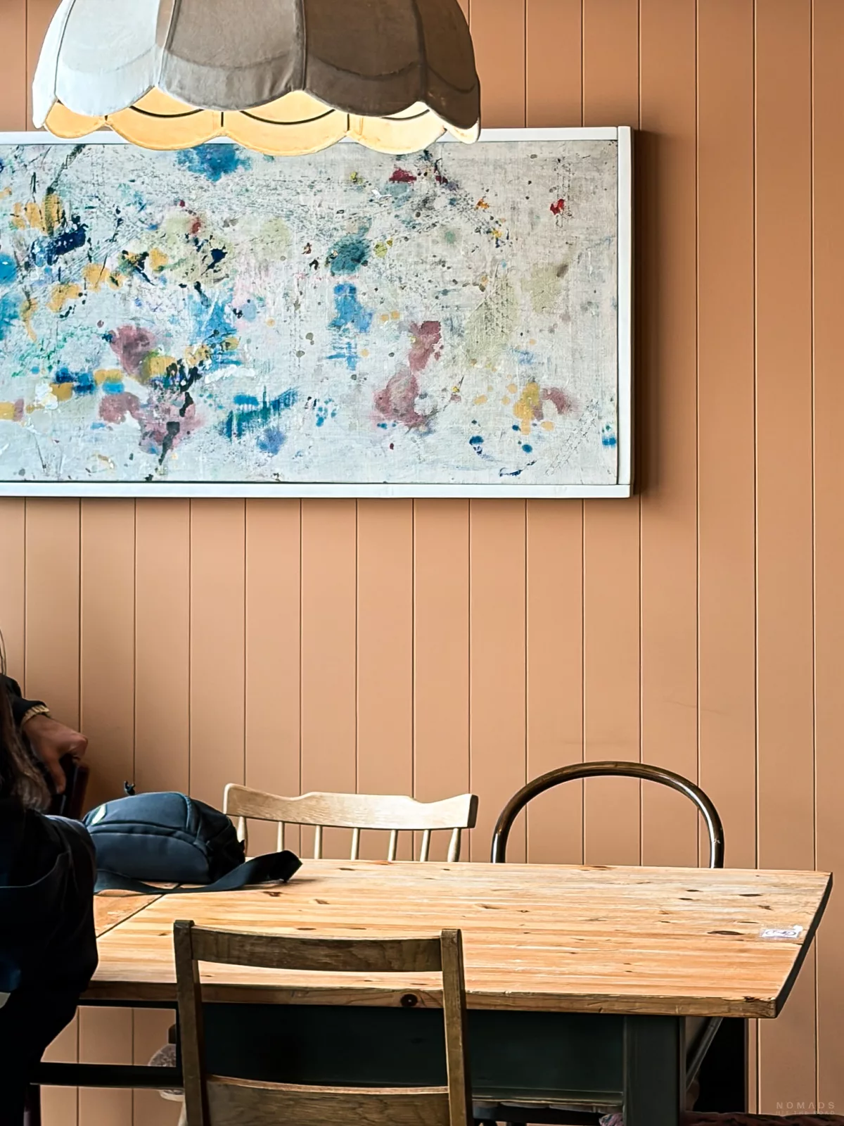 Holztisch und Gemälde and er Wand im Henningsvær Lysstøperi and Cafe