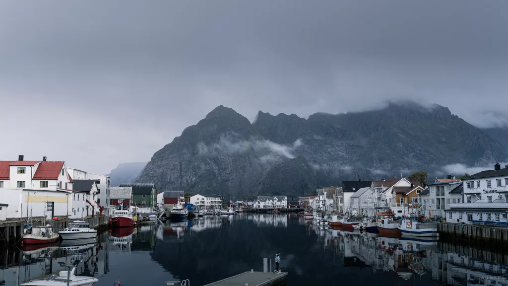 Frau steht auf einem Steg am Hafen in Henningsvær