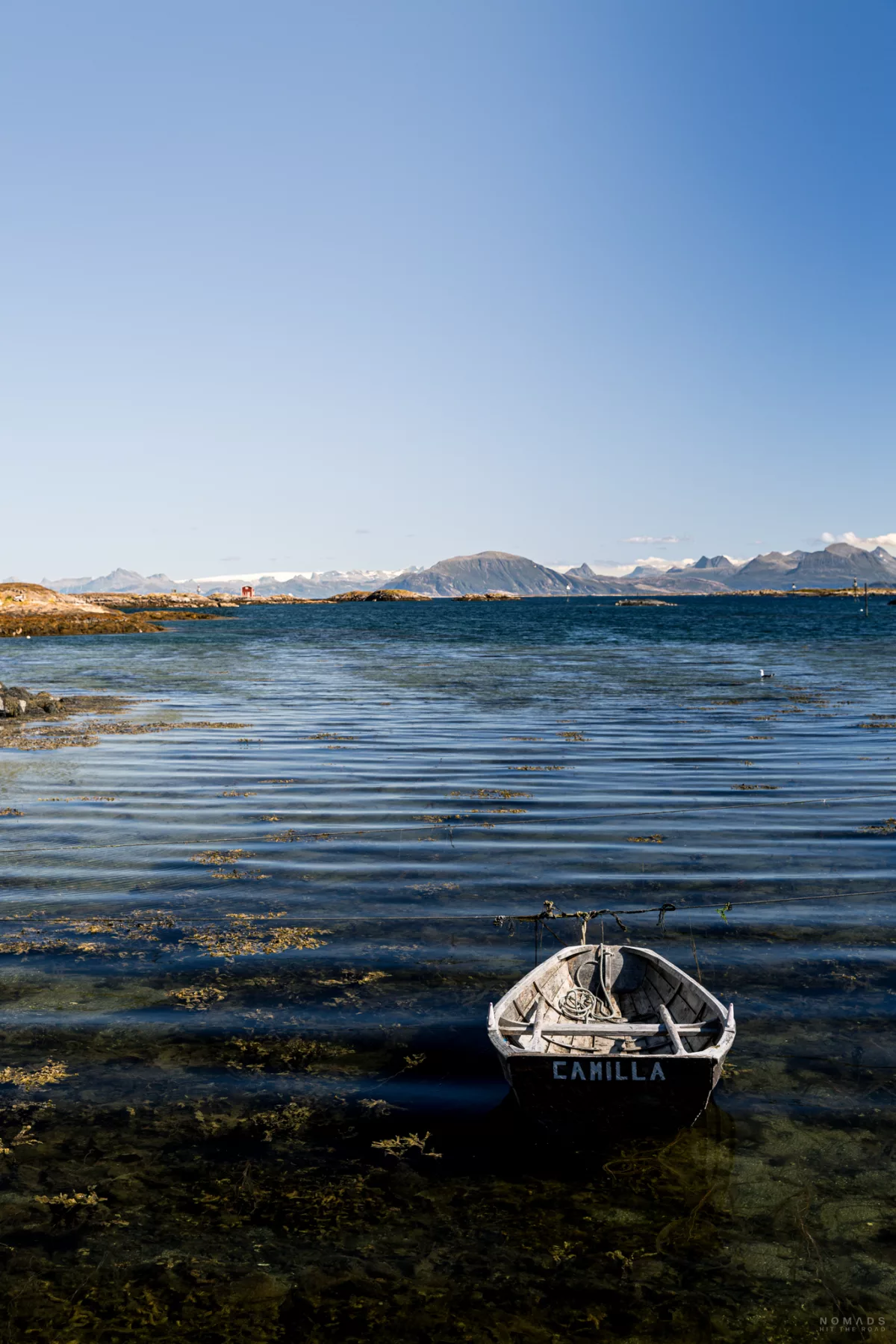 Kleines Holzboot Camilla auf dem Wasser mit Blick auf die Berge und Gletscher weit im Hintergrund