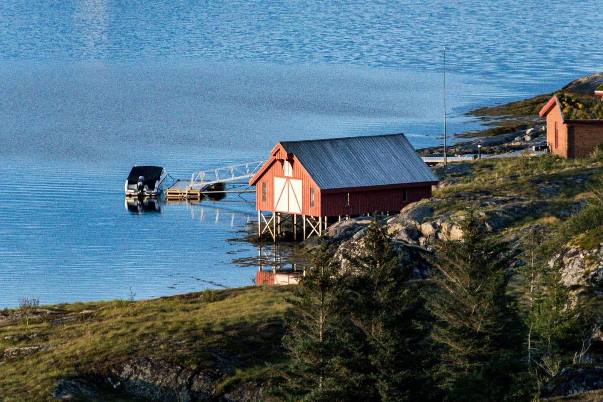 Rotes Bootshaus mit einem Boot am Anleger