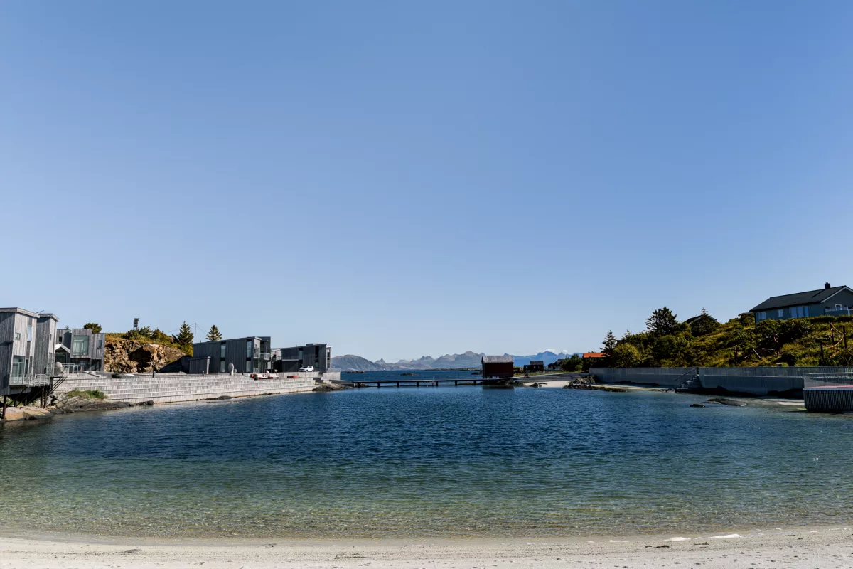Blick auf den Badestrand auf Lovund mit Häusern am Ufer