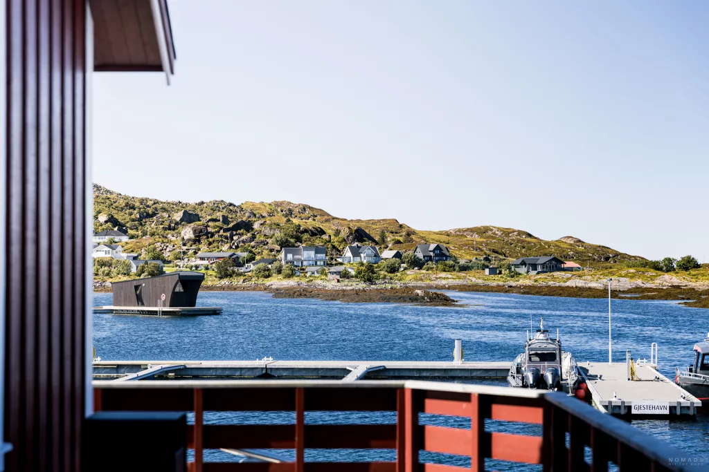 Blick von der Terrasse des The Coast Coffee auf Lovund auf Meer und Häuser am Ufer