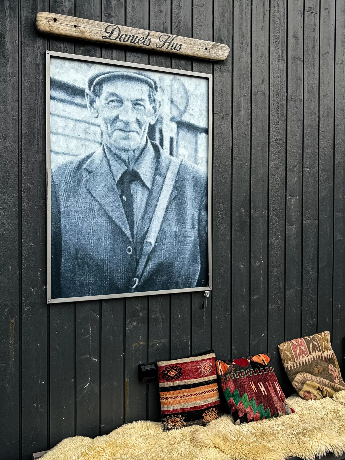 Terrasse mit Bild, Schild und Sitzbank von Daniels Hus