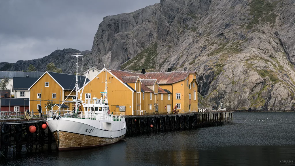 Gelbes Gebäude am Hafen mit einem Boot davor in Nusfjord