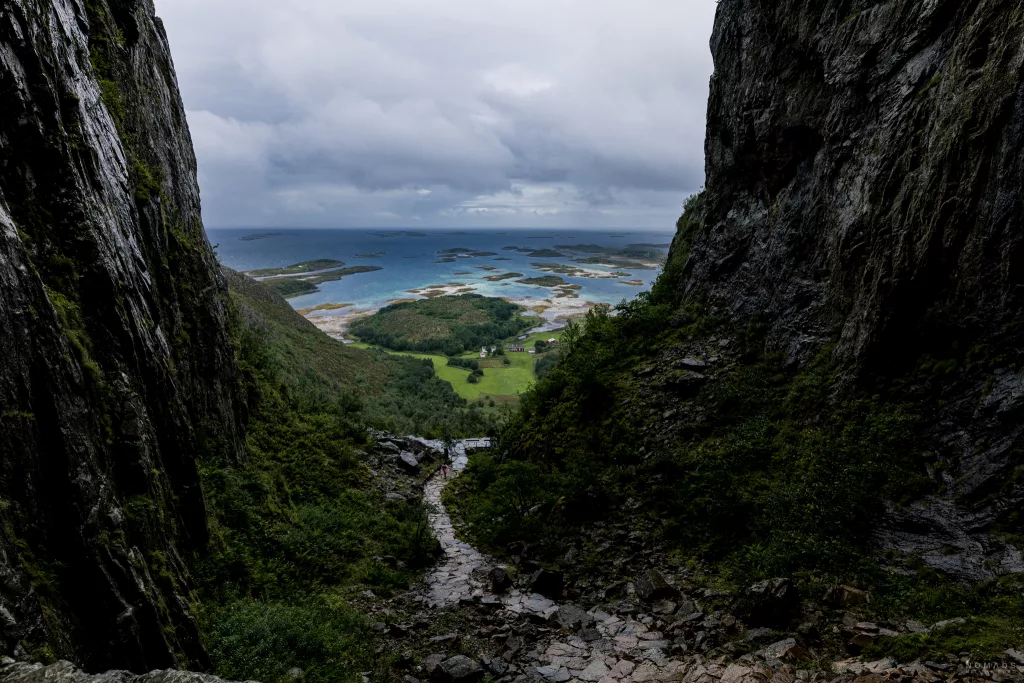 Blick aus den Felsen des Torghatten auf blaues Wasser und kleine grüne Inseln