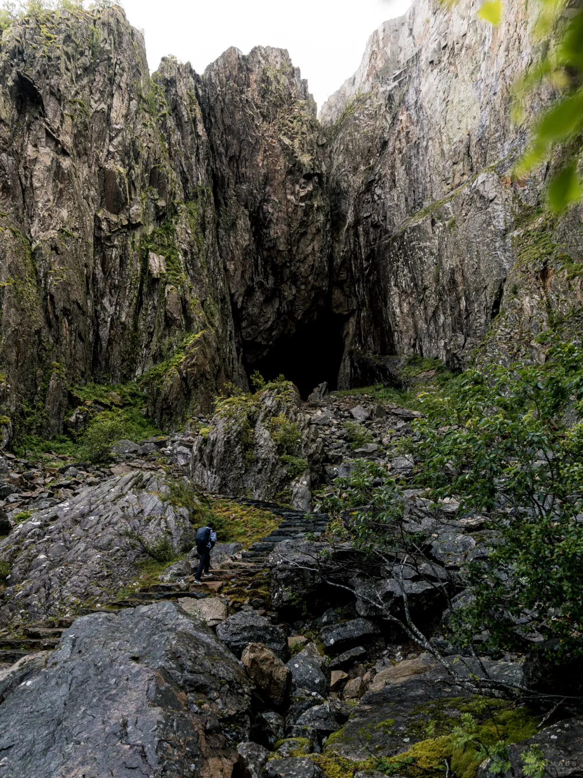 Mensch läuft auf den Sherpatreppen hoch zum Loch im Torghatten
