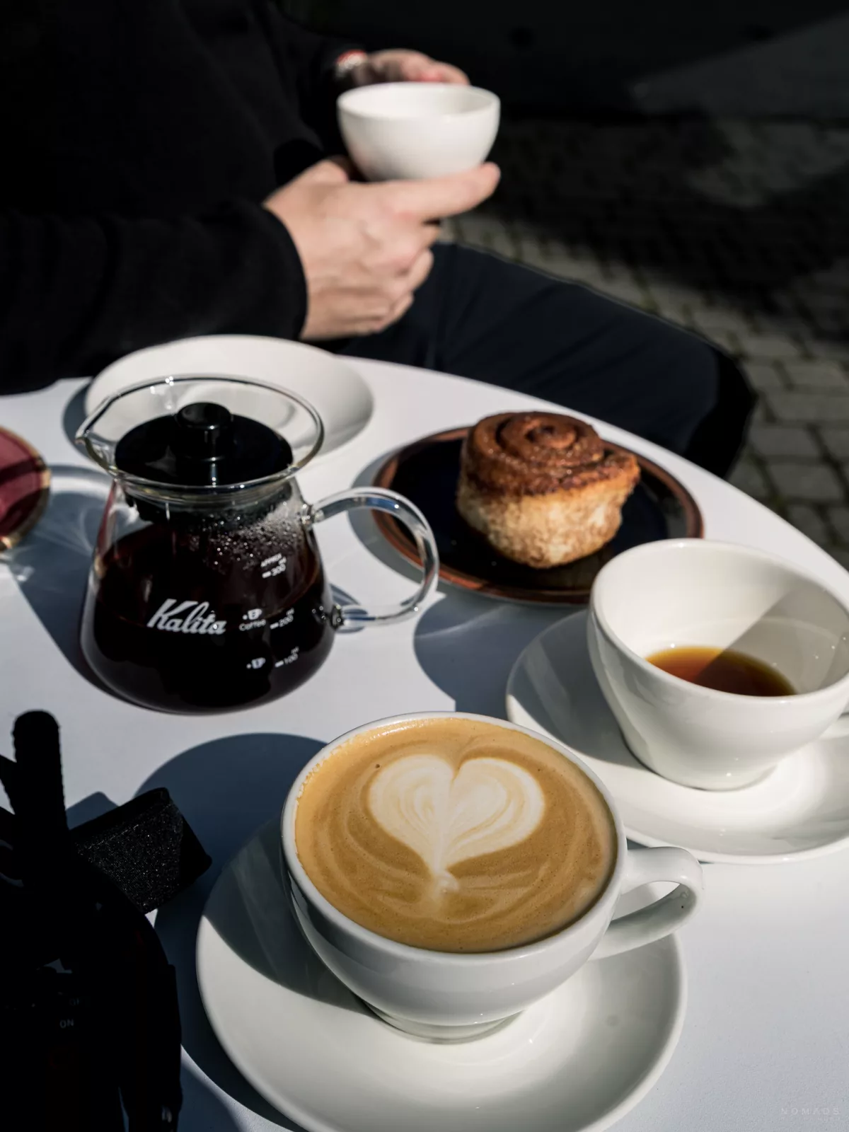 Gebäck, Kaffeetassen und Kaffeekanne stehen auf einem Tisch