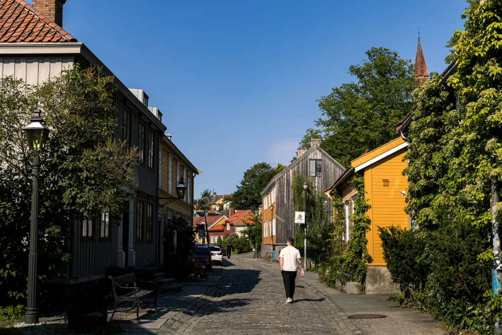 Mann läuft im Tshirt durch die Gassen von Bakklandet in Trondheim