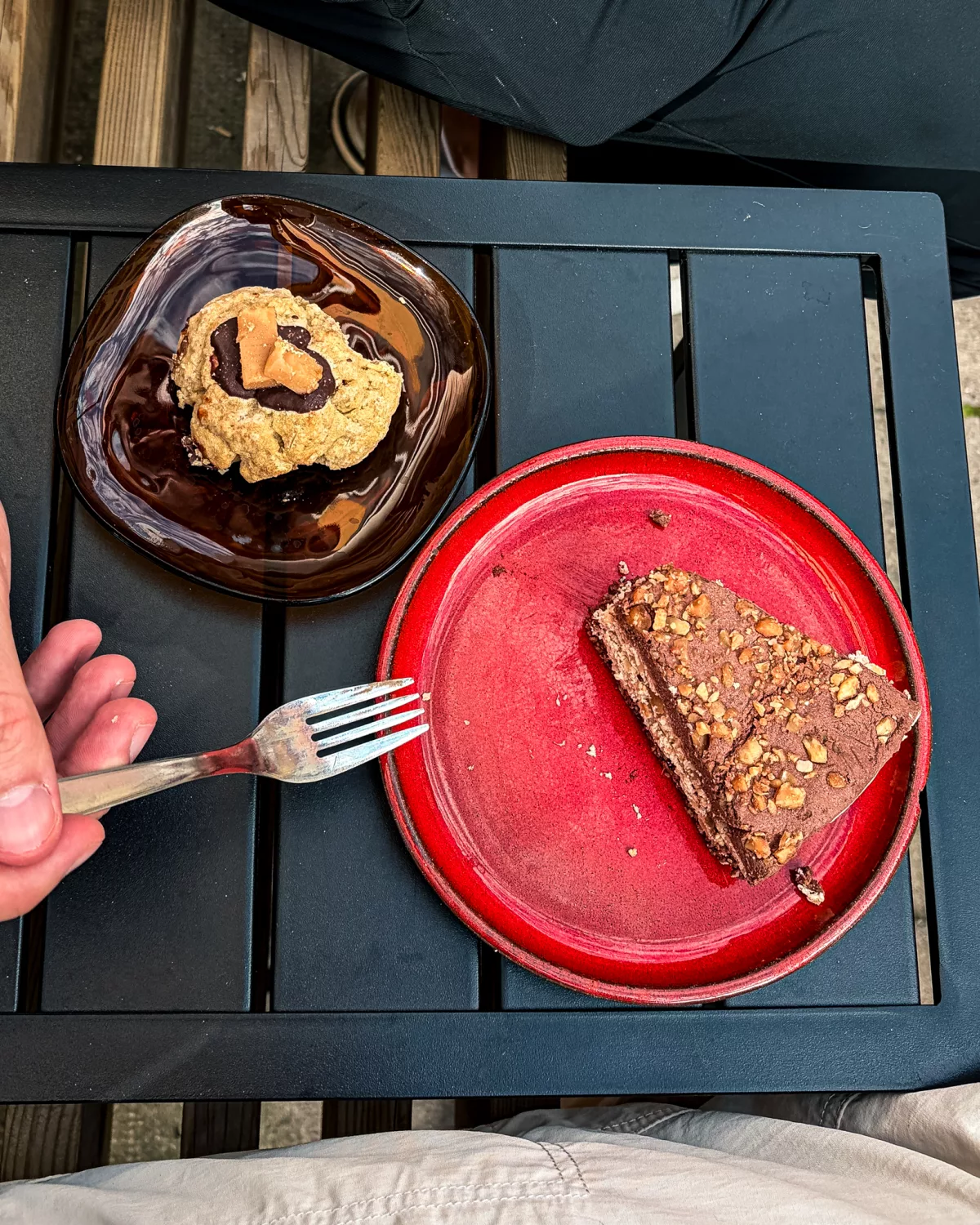 Stück Kuchen auf einem roten Teller und ein Cookie in einem Café