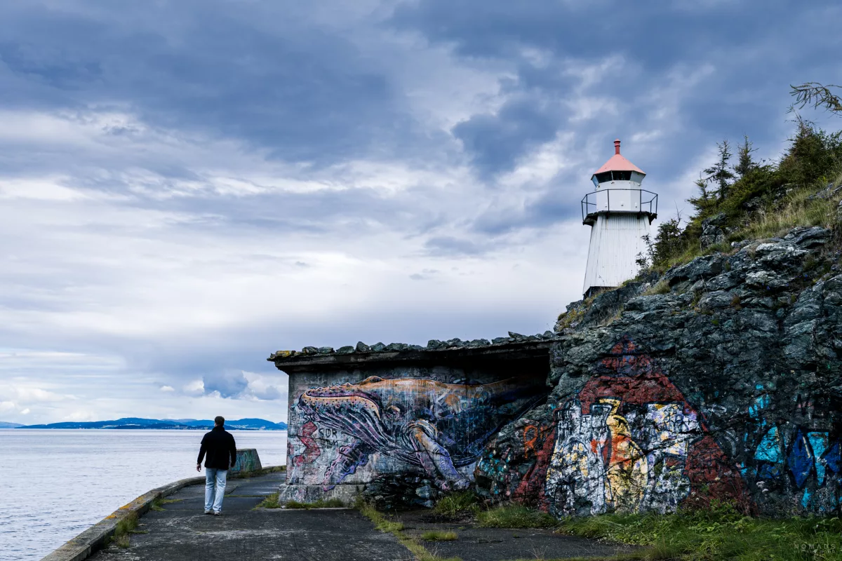 Mann läuft am Stu Bunker’n Badstu entlang, an dem ein Street-Art-Wal prangt