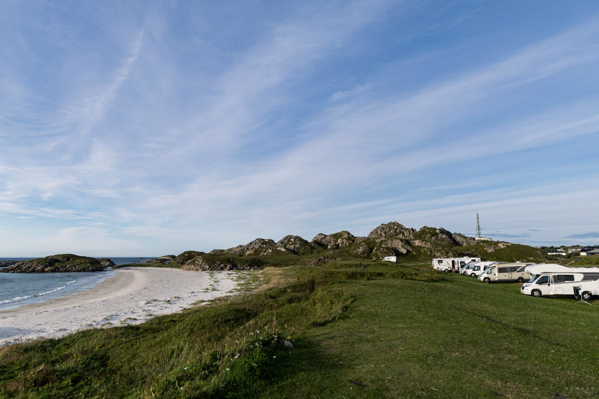 Blick vom Andenes Campingplatz, auf dem Wohnmobile stehen, auf den Strand und das Meer