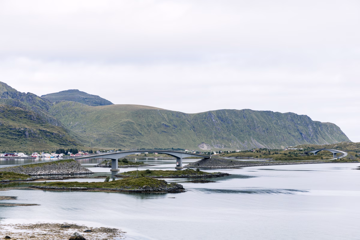 Blick auf eine Brücke über Wasser und Berge im Hintergrund auf den Lofoten