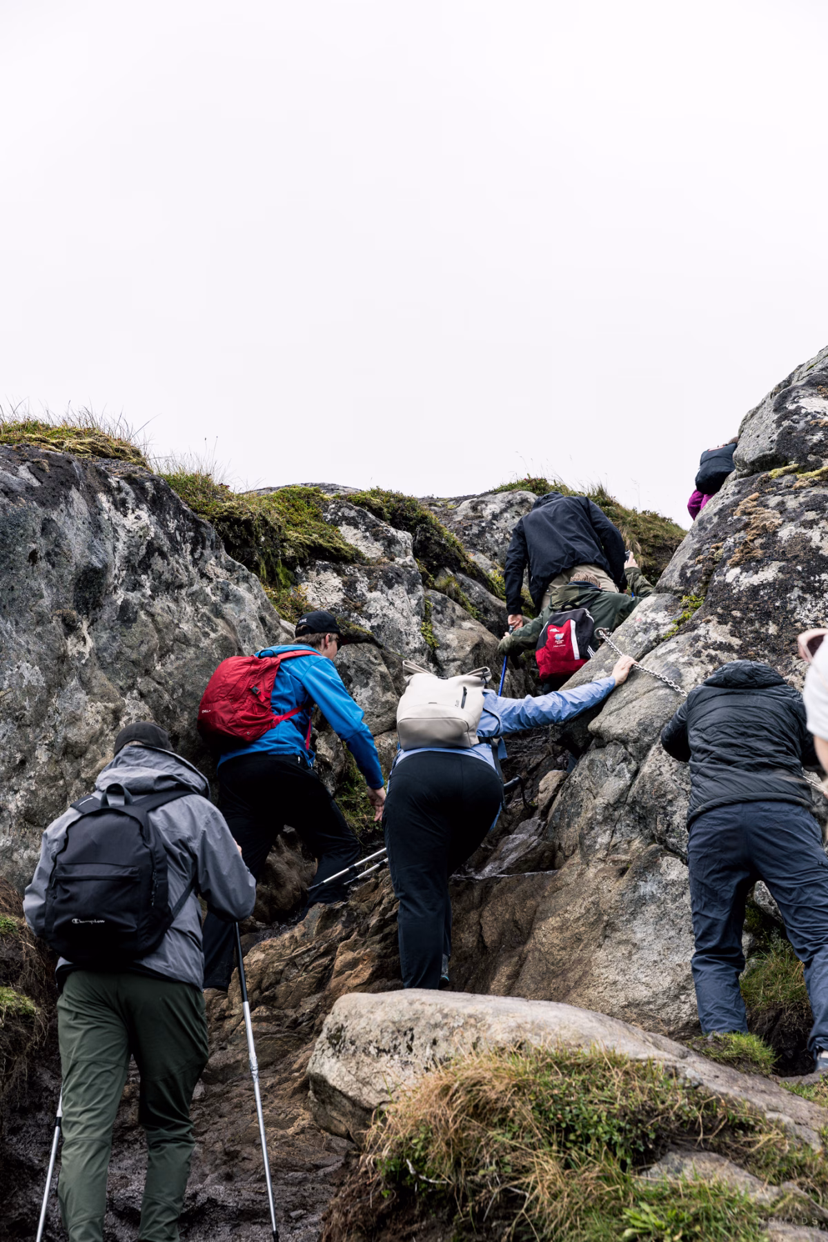 Menschen kraxeln an Felsen hoch