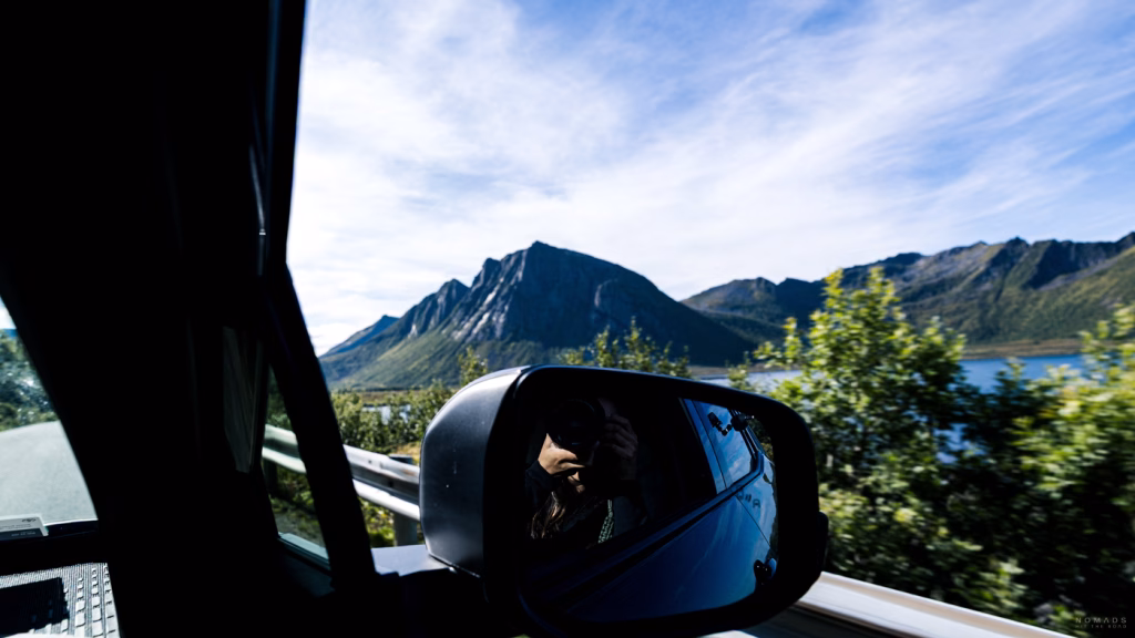 Blick aus dem Mietwagen in Norwegen auf Berge und Fjord während der Fahrt