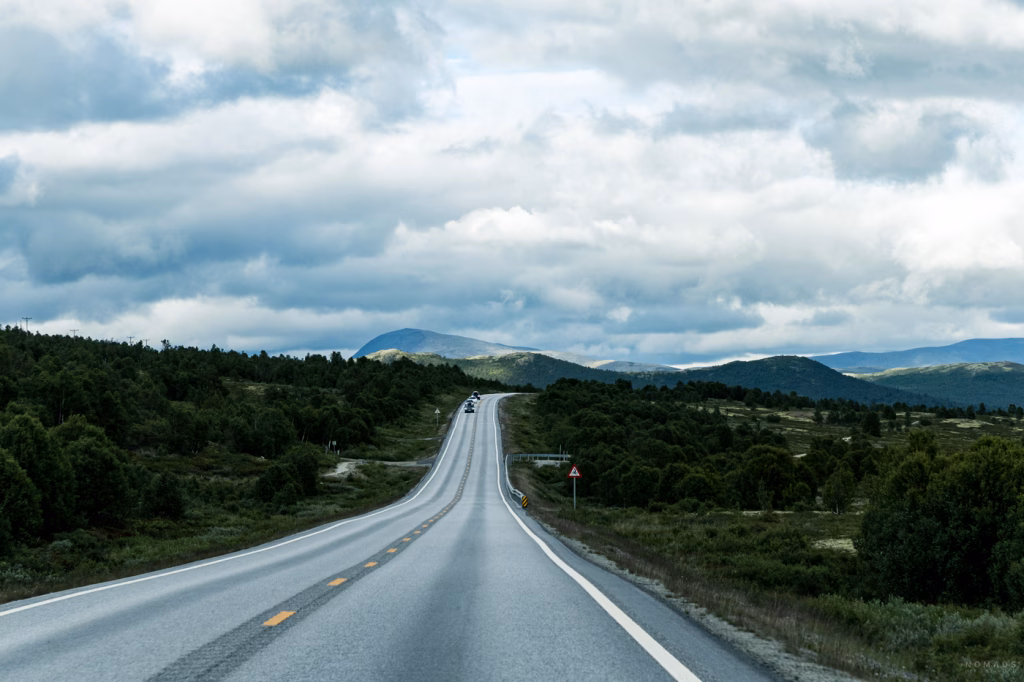Leere Landstraße durch Norwegens Berglandschaft bei einer Rundreise mit dem Mietwagen
