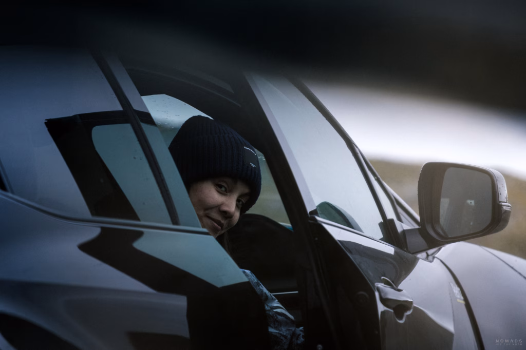 Frau im Mietwagen in Norwegen während eines Roadtrips durch die Berglandschaft