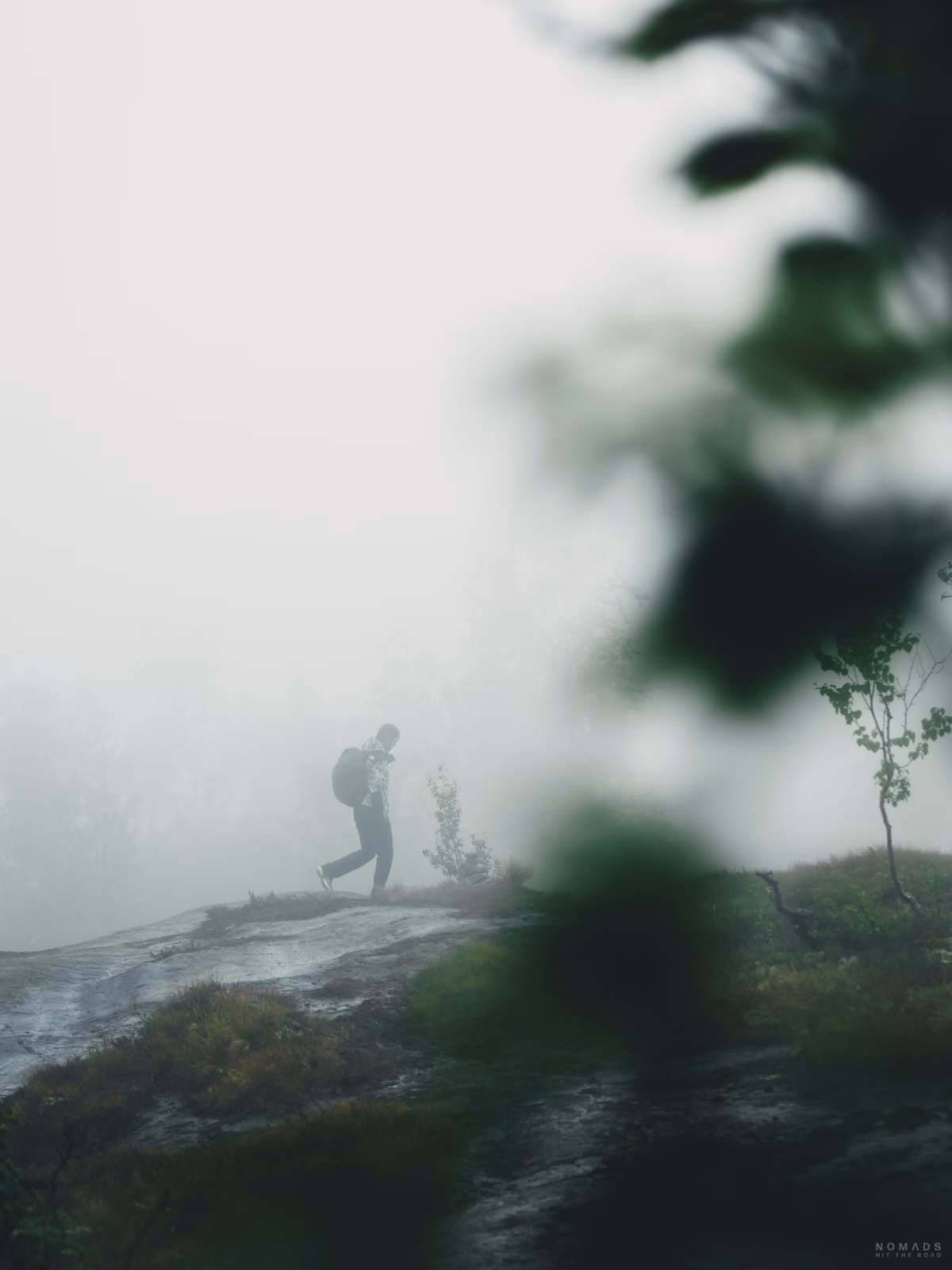 Frau läuft im Nebel auf Felsen herum