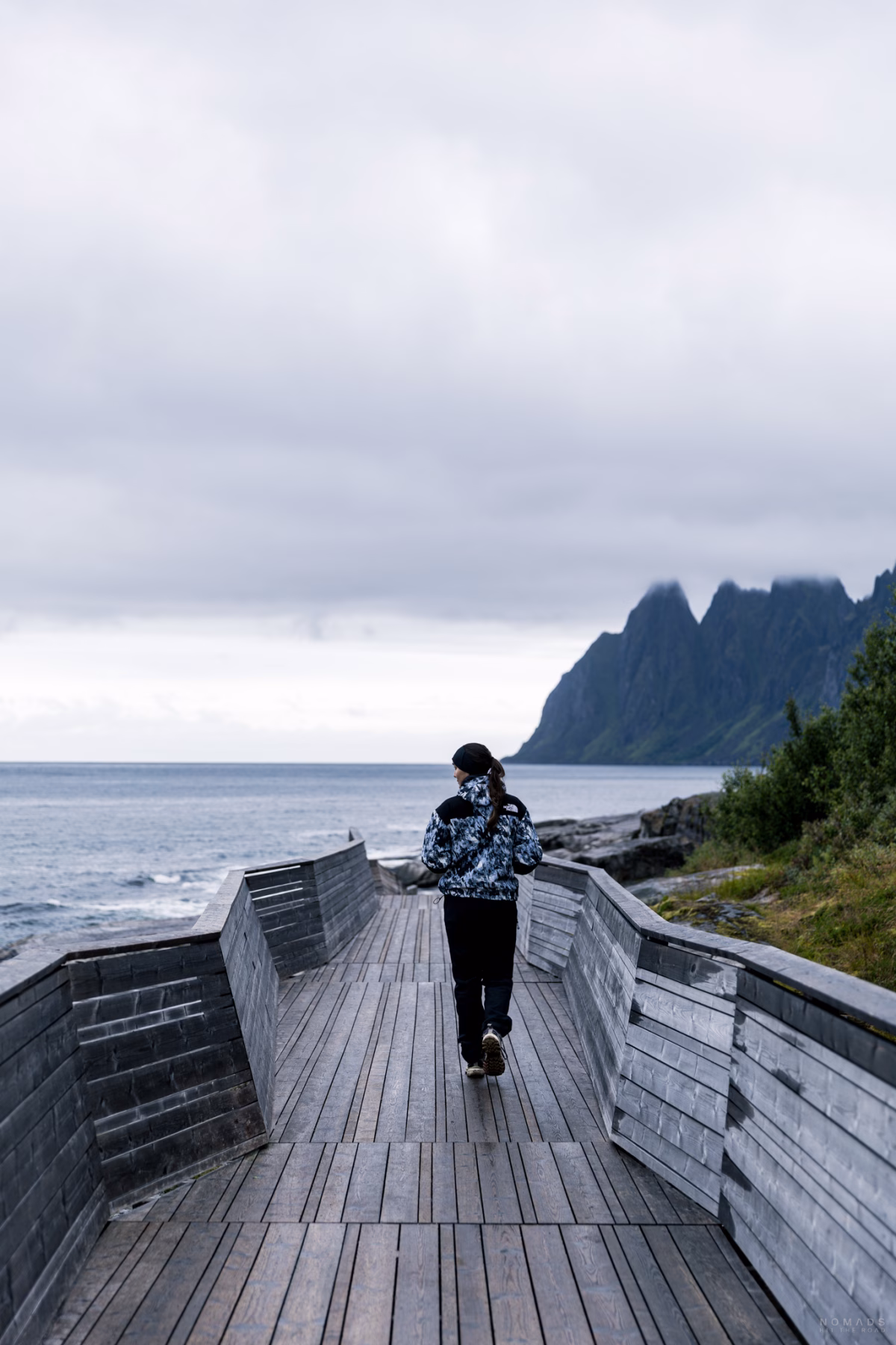 Frau läuft über den Holzsteg Tungeneset auf Senja in Norwegen