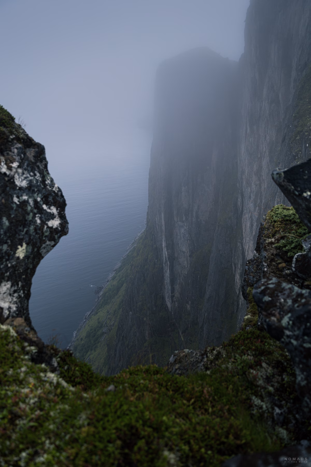 Blick an einem Berghang in den Fjord bei Nebel auf dem Hesten in Norwegen